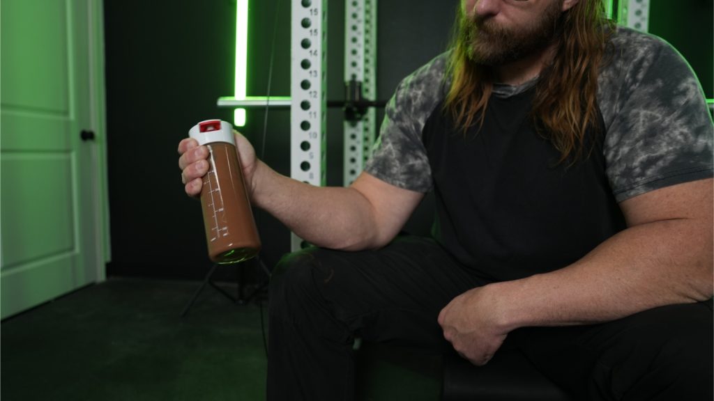BarBend tester shaking ONNIT plant-based protein.