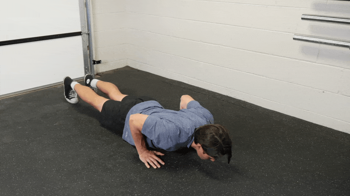 A person performing the plyo push-up in the gym.