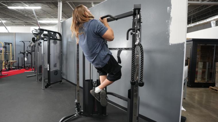 Our BarBend tester doing a chin up on the Titan Fitness Functional Trainer.