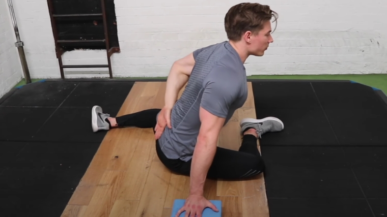 A person doing the 90/90 stretch.
