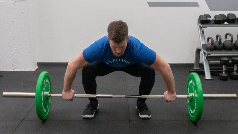 A person performing the muscle snatch incorrectly.
