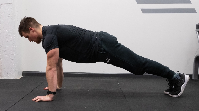 The third push-up position, with the body elevated back to a plank position.