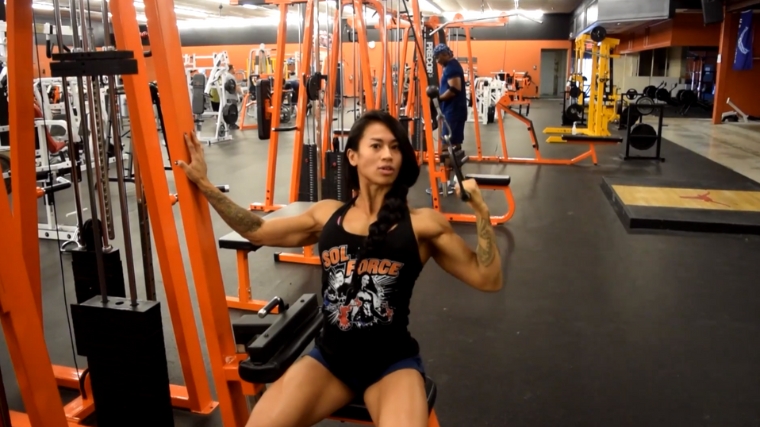 A person doing the single arm lat pulldown.