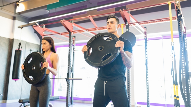 Two people working with weight plates.