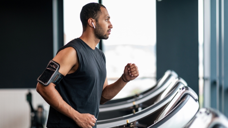 A person walking on a treadmill in the gym.