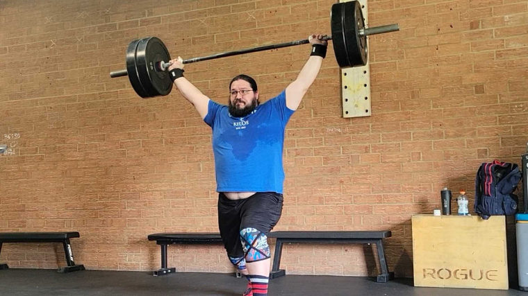 Tester does an overhead lift with the Bells of Steel Might Wrist Wraps on.