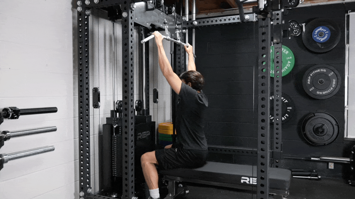 A person doing a lat pulldown with a cable machine. 
