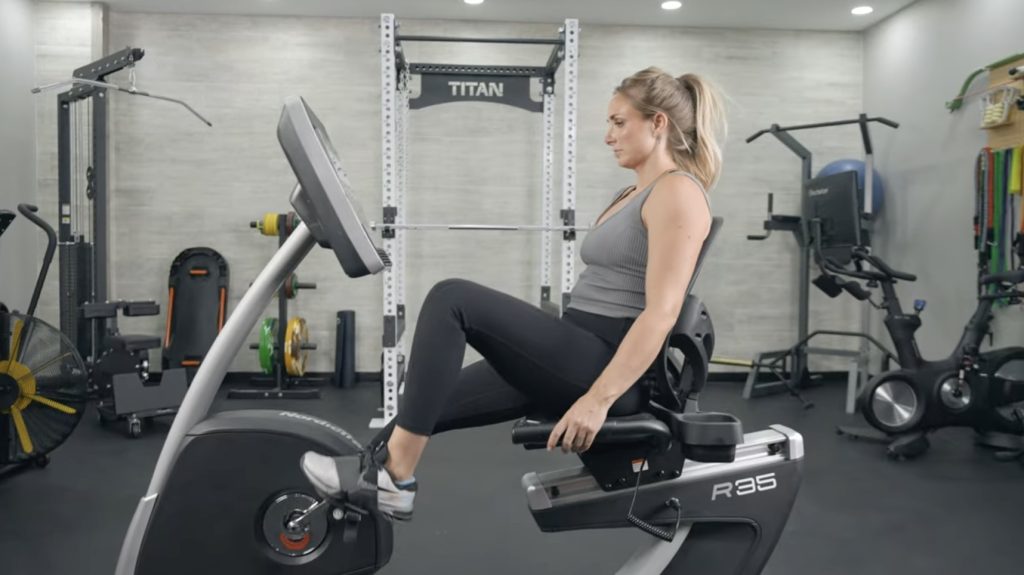 A woman using the NordicTrack Commercial R35 exercise bike