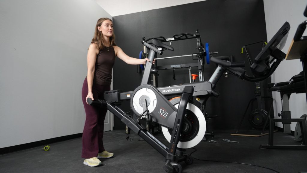 A woman moving the NordicTrack S22i exercise bike
