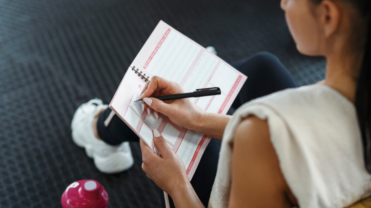 A woman making up a workout plan.