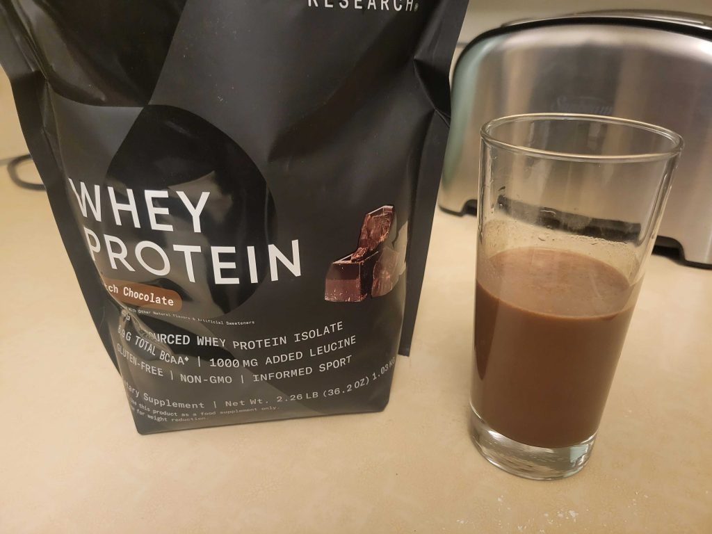 A bag of Sports Research Whey Protein Isolate with shake.