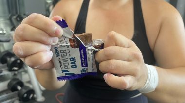 a person opening a protein bar