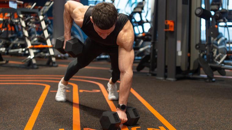 A bodybuilder doing a dumbbell plank row.