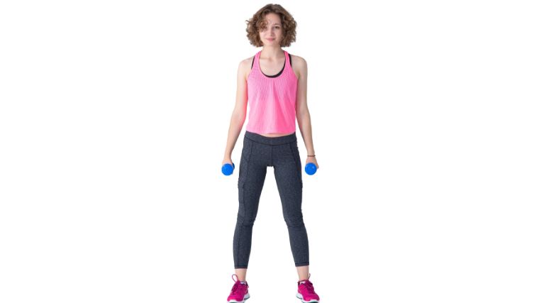 Standing tall holding a dumbbell in each hand.