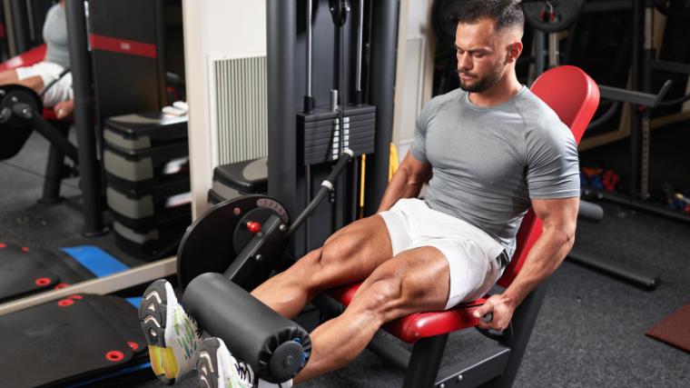 A person working out on the leg extension machine.