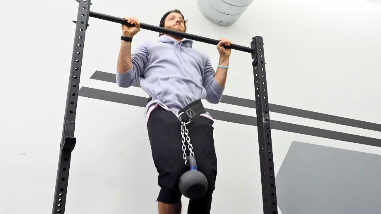 A person doing a weighted pull-up.