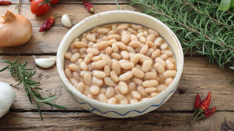 Boiled white beans in a white bowl.