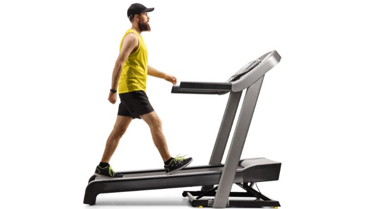 A gymgoer walking on an inclined treadmill.