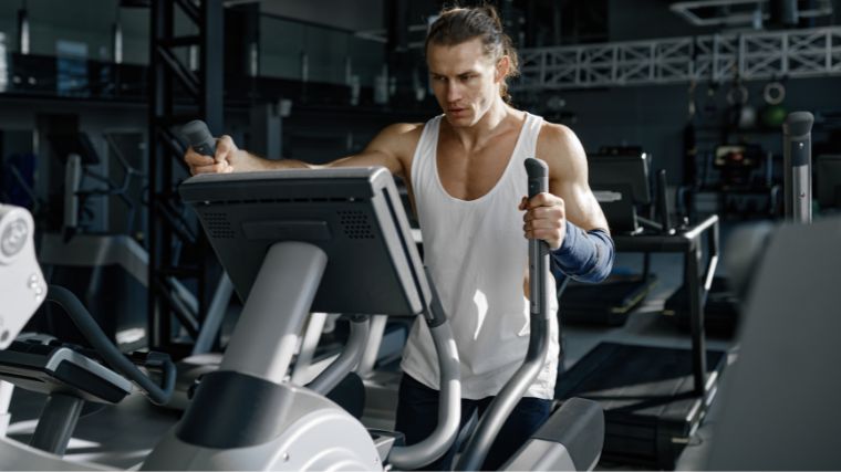 A gymgoer working out on an elliptical.