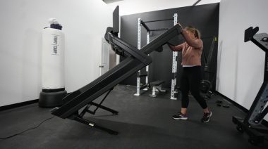 Side view of a person unfolding the NordicTrack 1750 treadmill.