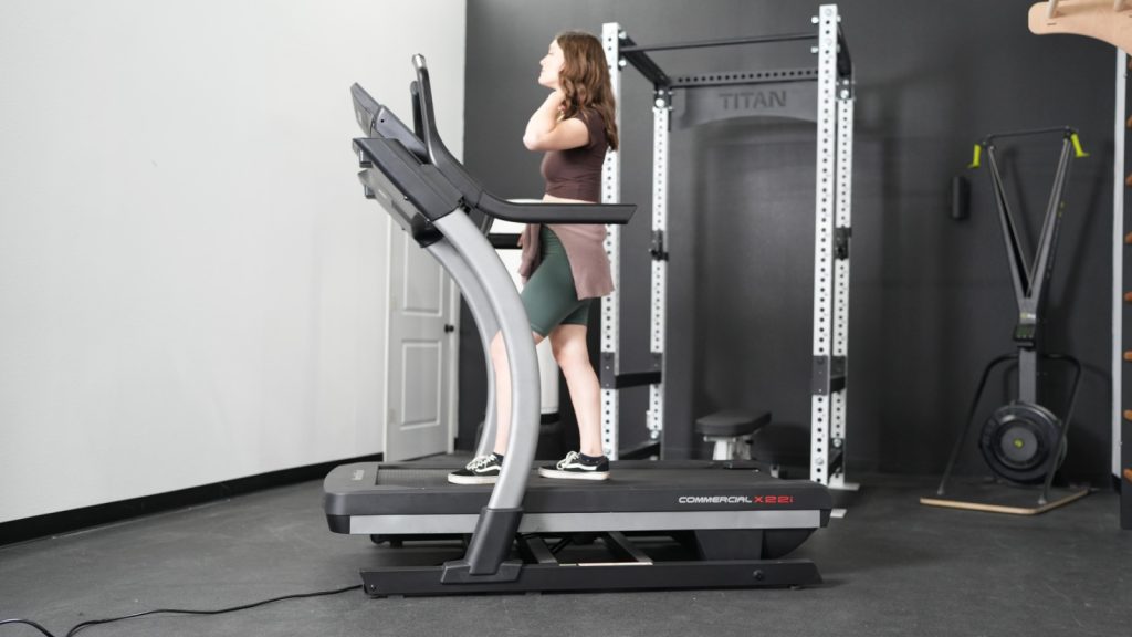 A woman is shown walking on the NordicTrack X22i treadmill.