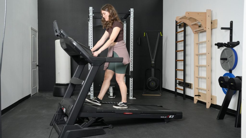 A woman walking at an incline on the Sole F63 treadmill.