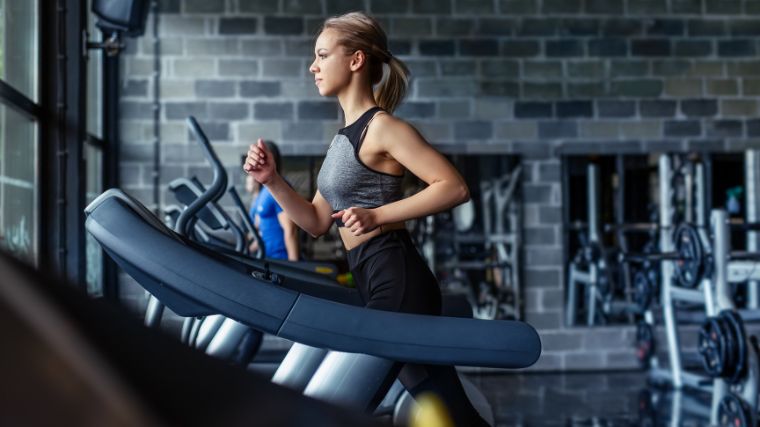 An athlete working out on a treadmill in the gym.