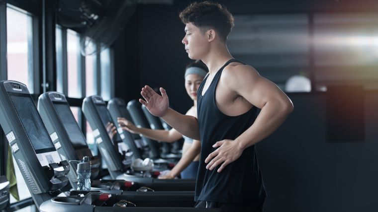 A bodybuilding walking on a treadmill. 