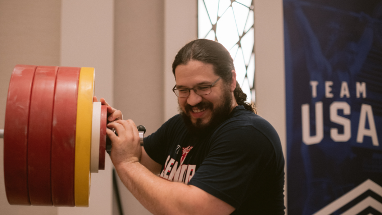 Caine Wilkes smiles during a weightlifting workout.