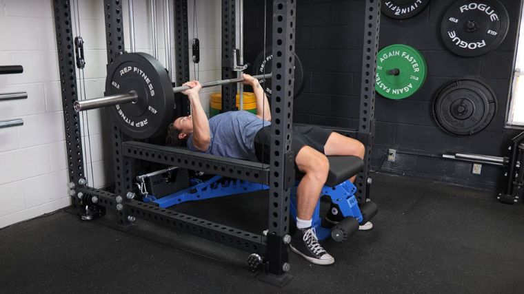 A person performing the barbell bench press exercise.