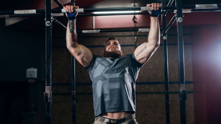 An athlete doing pull-ups to exercise their biceps.
