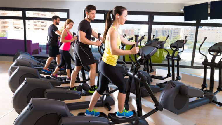 A group of people working out with ellipticals.