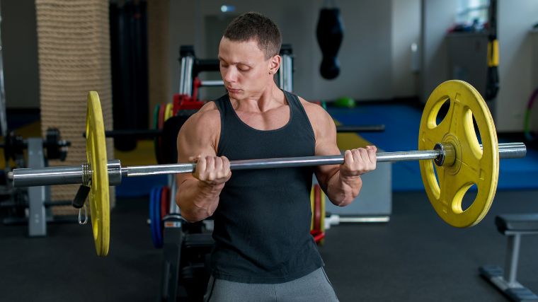 A person lifting a barbell in the gym.