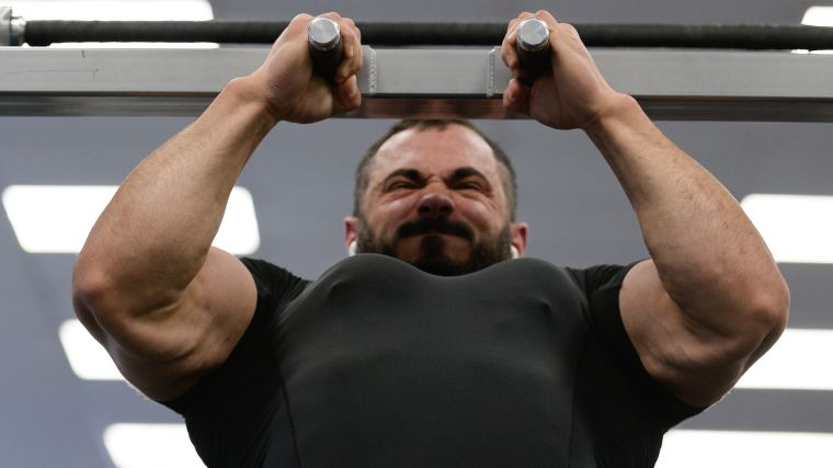 A bodybuilder performing a neutral grip pull-up.