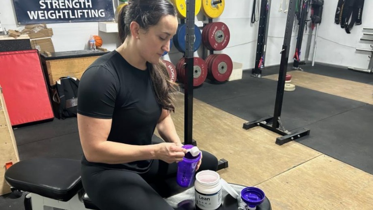 Our tester mixes Transparent Labs LEAN in a gym.