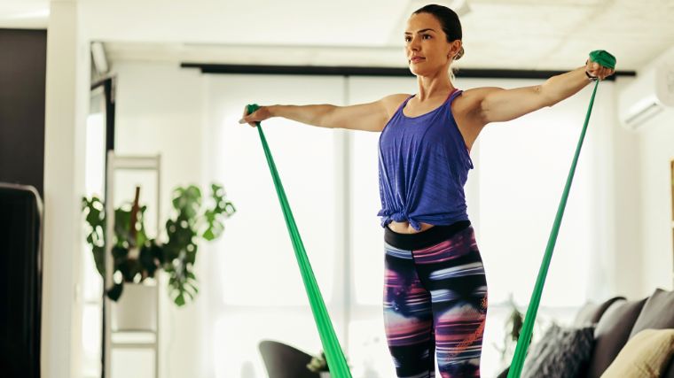 A person working out with a resistance band in their living room.