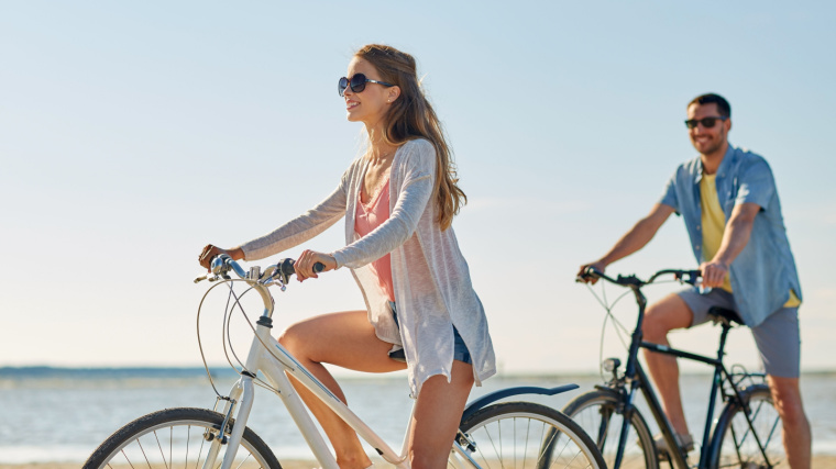 Two persons happily riding bicycles.