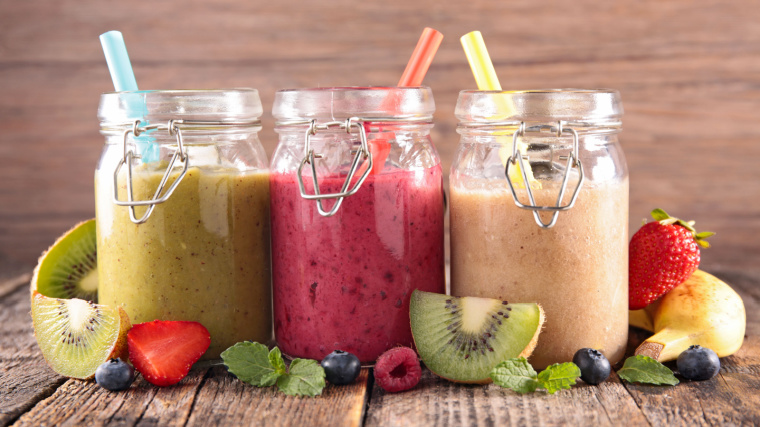 Three glasses of protein shakes with fruits.
