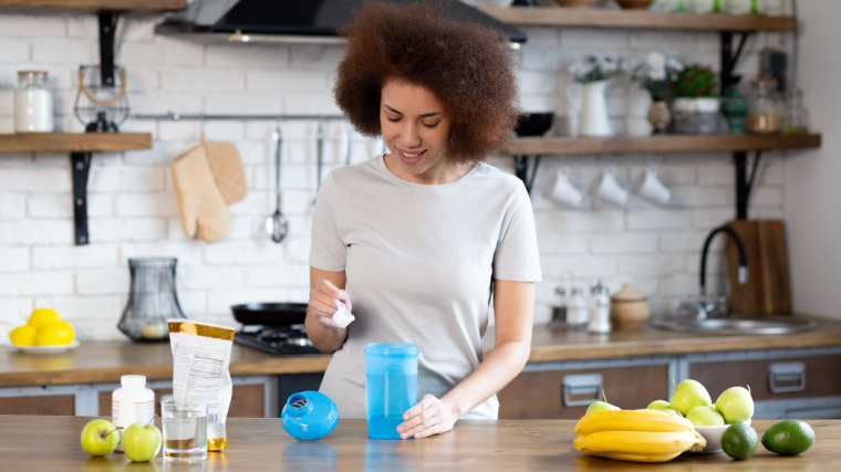 A person making meal replacement shake with protein powder.