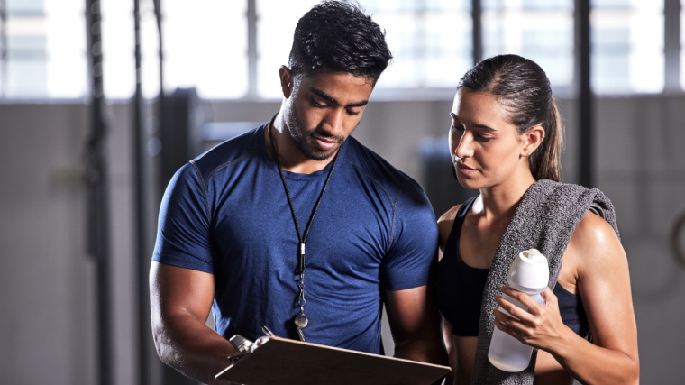 A personal trainer discussing with a client at the gym.
