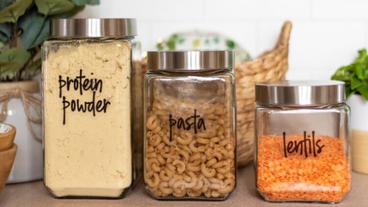 A jar of protein powder, pasta, and lentils.