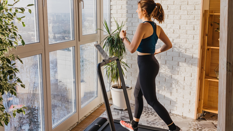 A person warming up on a treadmill at home. 