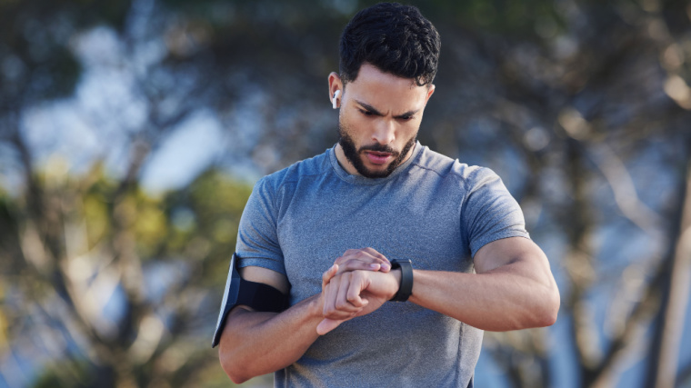 An athlete setting his watch for his marathon training.