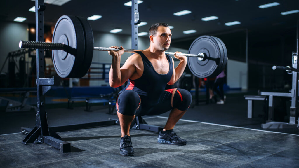 A powerlifting doing some back squats with a barbell.