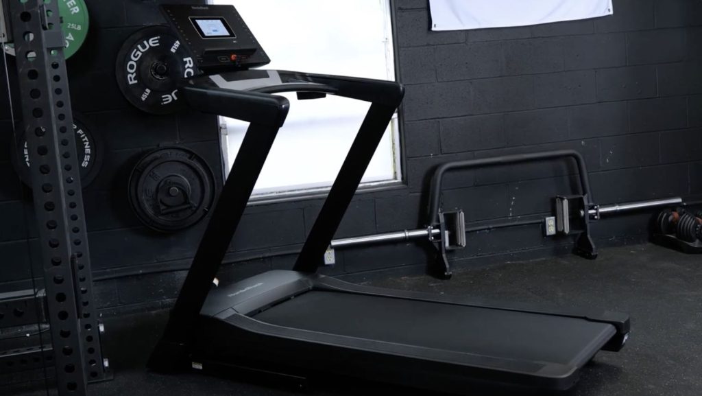 A treadmill in a garage gym.