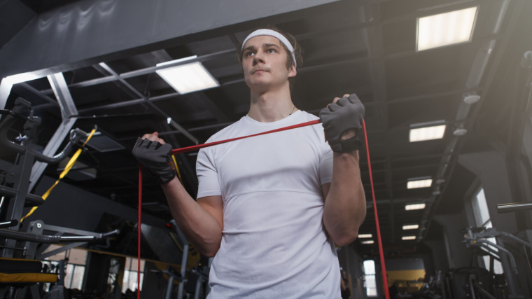 An athletic person doing biceps curls with a resistance band.