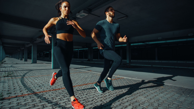 Young sports couple running in the urban environment.