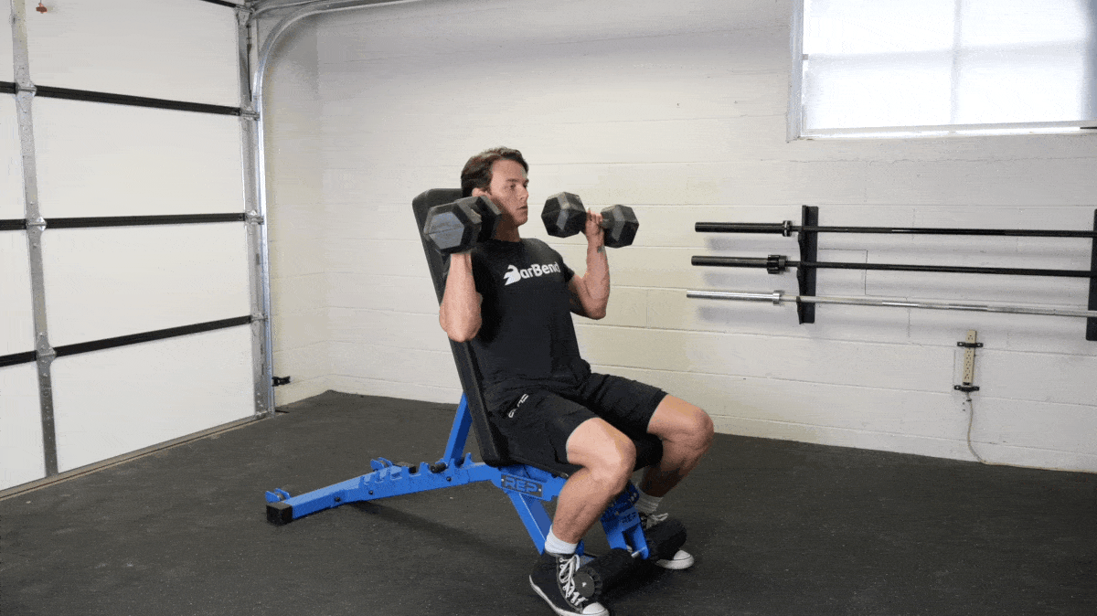 A person doing a seated dumbbell shoulder press exercise