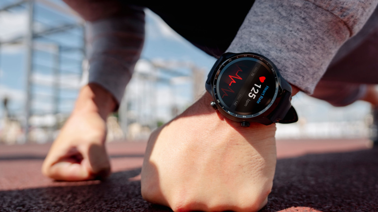 A heart beat monitor on a smartwatch of a person doing push ups in the stadium.