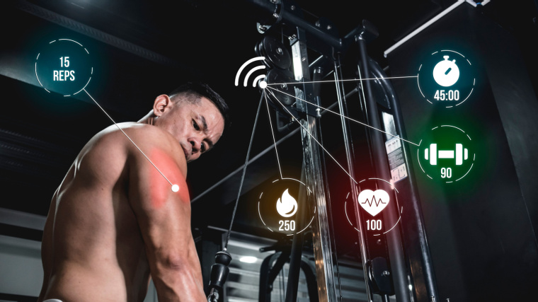 Smart gym equipment monitoring a fit person's workout tracking calories, time, heart rate, reps and etc.